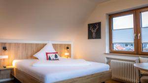 ein Schlafzimmer mit einem großen weißen Bett und einem Fenster in der Unterkunft Gasthaus Hirschenstube & Gästehaus Gehri in Waldkirch