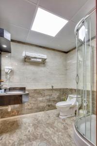 a bathroom with a shower and a toilet and a sink at Royal Hotel in Sharjah