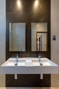 uma casa de banho com dois lavatórios e dois espelhos em English Point Marina Luxe C405 em Mombaça