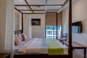 ein Schlafzimmer mit einem großen Bett und einem TV in der Unterkunft English Point Marina Luxe C405 in Mombasa