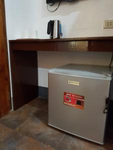 a small white refrigerator sitting under a desk at Marianita's cottages in Mambajao