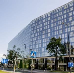 ein großes Glasgebäude mit einem Schild davor in der Unterkunft Luxury Apartments Seveeu in Warschau