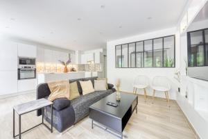 a living room with a couch and a table at Smart living - Idéal amis et famille -10 mn Disneyland - 20 mn Paris in Torcy