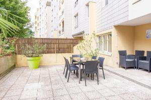 a patio with a table and chairs and a fence at Smart living - Idéal amis et famille -10 mn Disneyland - 20 mn Paris in Torcy