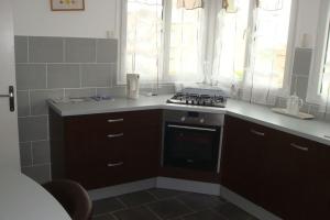 a kitchen with a stove and a sink and windows at MAISON GRAND LUXE PROX. STVAAST LA HOUGUE-BARFLEUR in Saint-Pierre-Église