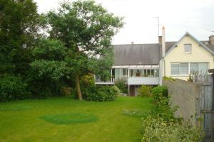 a house with a green yard with a fence at MAISON GRAND LUXE PROX. STVAAST LA HOUGUE-BARFLEUR in Saint-Pierre-Église