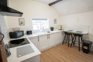 Una cocina con gabinetes blancos y encimera. en Shakespeare's Nest, en Stratford-upon-Avon 9 fotos más