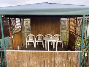 a table and four chairs on a deck with a tent at Bungalow im Grünen in Werneuchen