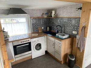 a kitchen with a washing machine and a washer at Bungalow im Grünen in Werneuchen