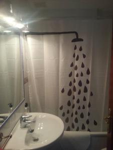 a bathroom with a sink and a shower curtain at Ático en Rota, junto a la playa in Rota