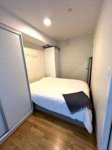 Habitación pequeña con cama blanca. en Very cozy and central appartment near the city centre, en Tromsø