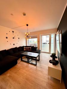 sala de estar con sofá negro y mesa en Very cozy and central appartment near the city centre, en Tromsø