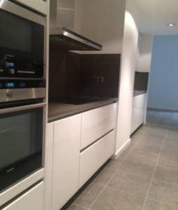 una cucina con armadi bianchi e piano cottura di Stunning & Modern Penthouse - Rambla - City centre a Tarragona