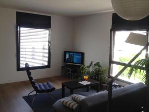 un soggiorno con divano, tavolo e TV di Stunning & Modern Penthouse - Rambla - City centre a Tarragona