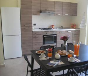 eine Küche mit einem Tisch und einem weißen Kühlschrank in der Unterkunft Casa Vacanze Kezia in Torrenova