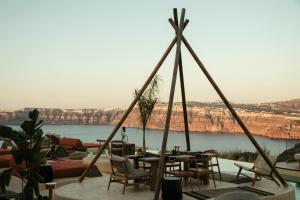a patio with a table with a view of a lake at Divino Caldera in Akrotiri