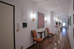 un couloir avec des chaises et une table dans un bâtiment dans l'établissement L.T. Savoia Palace & Cavour C.L., à Bari