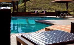 a swimming pool with chairs and an umbrella at Hilton Concord in Concord