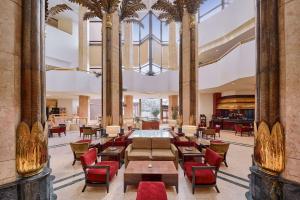 eine Lobby mit Tischen und Stühlen in einem Gebäude in der Unterkunft Ramses Hilton Hotel & Casino in Kairo