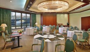 une salle de conférence avec des tables et des chaises ainsi qu'un lustre dans l'établissement Ramses Hilton Hotel & Casino, au Caire