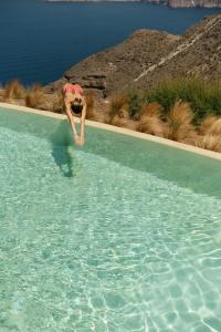 a man is diving into a pool of water at Divino Caldera in Akrotiri