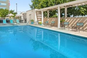 einen Pool mit blauen Stühlen, Tischen und Stühlen in der Unterkunft Home2 Suites by Hilton Austin Round Rock in Round Rock