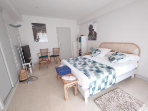 1 dormitorio con 1 cama, sillas y TV en TOUTUNCINEMER, en Saleilles