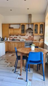 une cuisine avec une table en bois et des chaises bleues dans l'établissement Spacious Condo 5 min to Jurmala Beach, à Jurmala