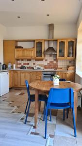 ユールマラにあるSpacious Condo 5 min to Jurmala Beachのキッチン(木製テーブル、青い椅子付)