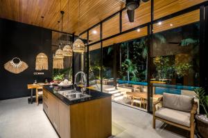 een keuken met een wastafel en een eetkamer met een zwembad bij Villa Homala by BaliSuperHost in Ubud
