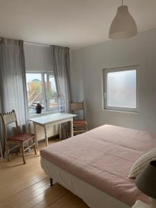 1 dormitorio con cama, mesa y ventana en Big apartments with mini-kitchen en Sint-Martens-Latem