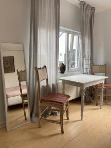 Big apartments with mini-kitchen في سينت-مارتنز-لاتيم: غرفة طعام مع طاولة وكرسي ومرآة