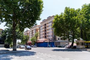 a city street with trees and a building at Rest House in İsmayıllı