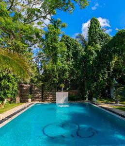 una piscina con una fuente en un patio con árboles en Villa Lyvie ayurvedic hotel, en Tangalle
