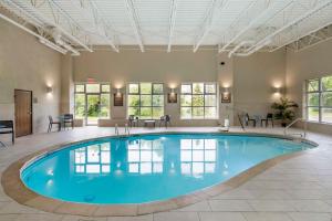 una gran piscina en una habitación con mesas y sillas en Comfort Inn North-Polaris, en Columbus