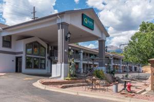 Quality Inn & Suites Manitou Springs at Pikes Peak في مانيتو سبرينغز: مبنى امامه طاولات وكراسي