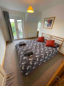 1 dormitorio con 1 cama grande con almohadas rojas en Modern Apartment by river - 20 mins to Belfast, en Dunadry