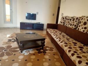a living room with a couch and a coffee table at فيلا للايجار في كمبوند سمر قند in Al Qaţā