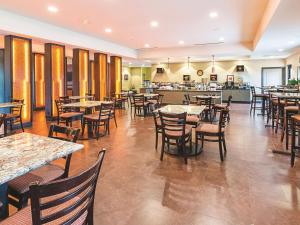 a restaurant with tables and chairs and a cafeteria at La Quinta by Wyndham Woodway - Waco South in Waco