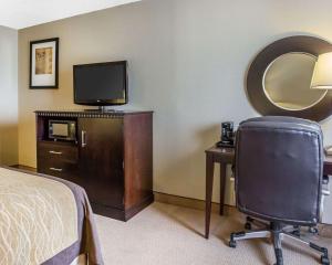 a bedroom with a bed and a desk with a television at Comfort Inn & Suites near Tinley Park Amphitheater in Tinley Park