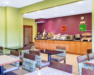 a restaurant with tables and chairs and a counter at Comfort Inn & Suites near Tinley Park Amphitheater in Tinley Park