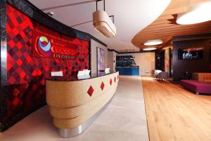 um átrio com um bar com uma parede xadrez vermelha em Ramada Encore Al Khobar Corniche- رمادا أنكور الخبر كورنيش em Al Khobar