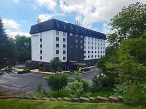 a large white building with a parking lot at Comfort Inn at the Park Hershey in Hershey