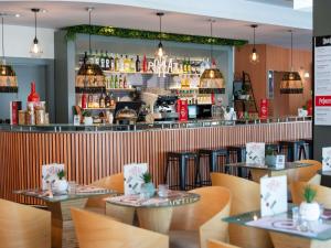 a restaurant with wooden tables and a bar at Ibis Madrid Alcobendas in Alcobendas