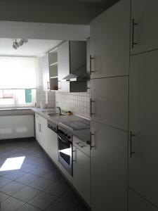 eine Küche mit weißen Schränken und einem Herd mit Backofen in der Unterkunft Ferienwohnung Kaulberg in Bamberg