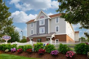 a house with a white fence and flowers at Hampton Inn & Suites - Cape Cod / West Yarmouth in West Yarmouth