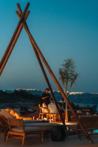 un groupe de personnes assises sur une terrasse avec des chaises dans l'établissement Divino Caldera, à Akrotiri