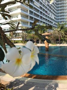 una piscina con flores blancas frente a un edificio en View Talay Condominium by Vlad Property en Pattaya South