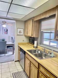 uma cozinha com armários de madeira, um lavatório e uma mesa em Island 1 em Kissimmee