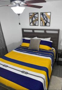 um quarto com uma cama com riscas amarelas e azuis em Island 1 em Kissimmee